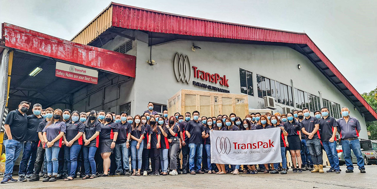 transpak-singapore-team-in-front-of-facility-and-crates