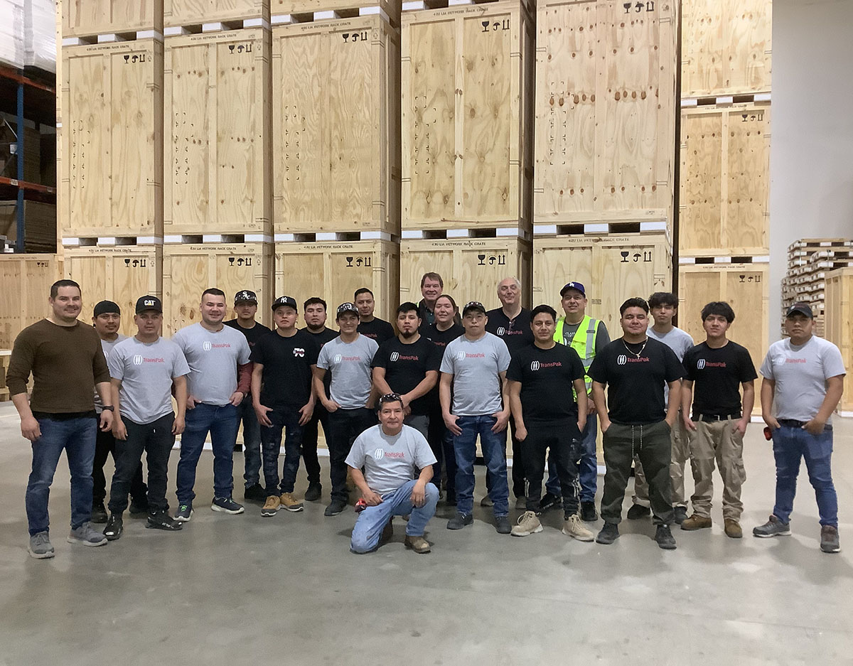 transpak-chicago-team-in-facility-with-crates-behind-them