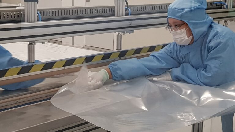 Transpak employee packaging with plastic wrap.