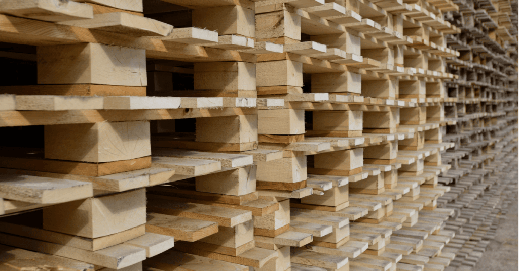 Large stack of new wooden pallets in a warehouse.
